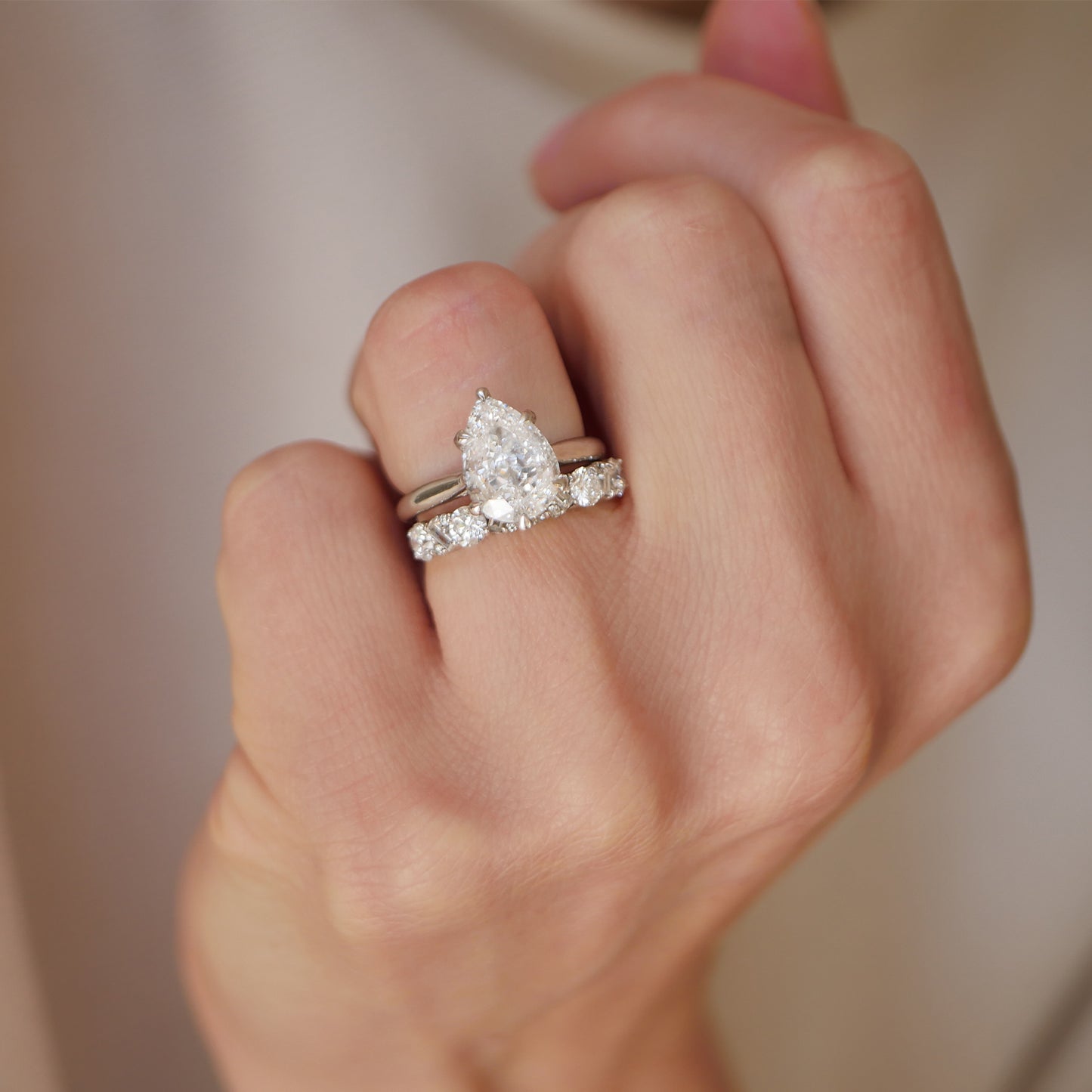 This exquisite lab-grown pear-shaped diamond, designed with antique flair, is complemented by a diamond confetti wedding band, offering a unique and dazzling combination for your special day.