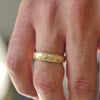 Man wearing 5mm 14k yellow gold floral-engraved wedding band.