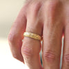 Man wearing 5mm 14k yellow gold floral engraved wedding band.