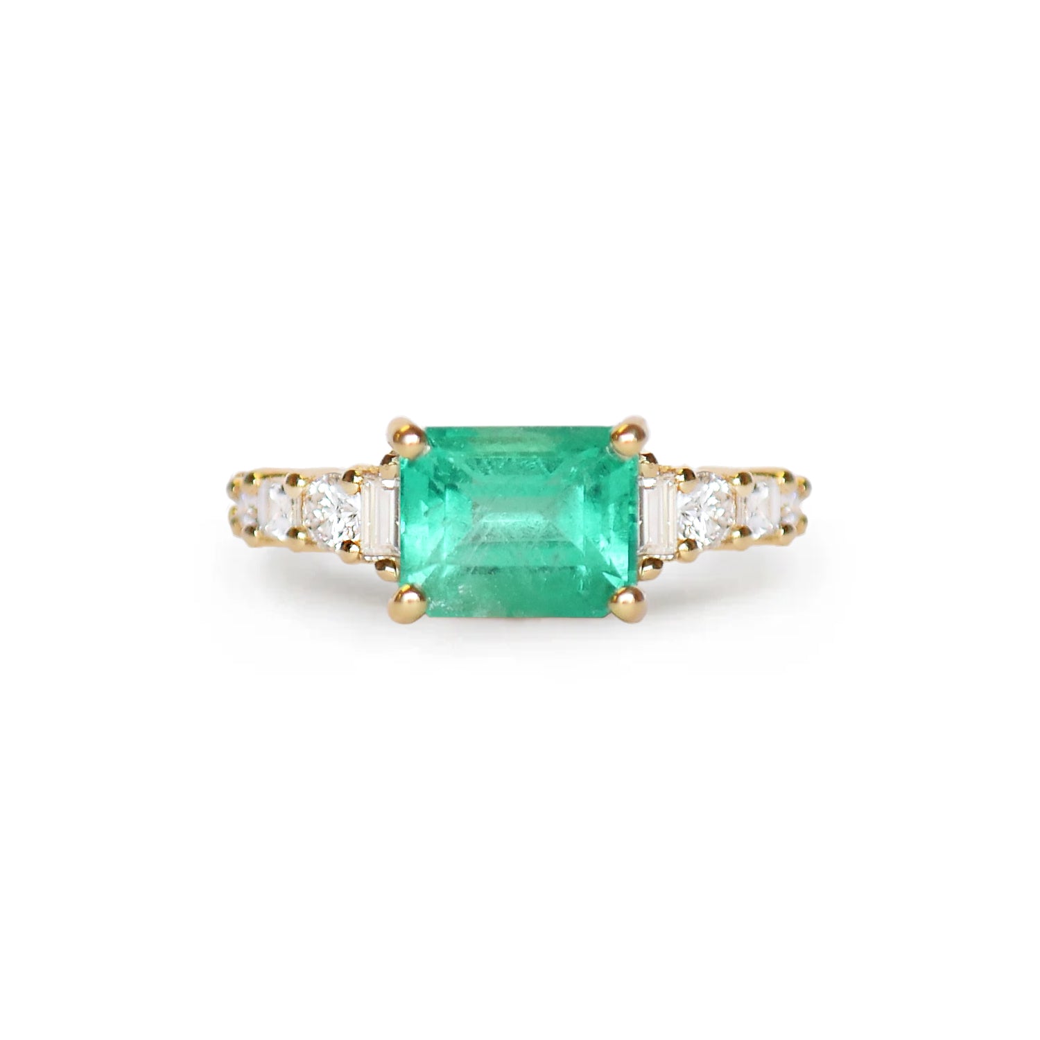 a stunning natural emerald cut Colombian emerald, enhanced by eight natural diamonds, creating a timeless and luxurious design.