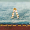A pair of vintage diamond hoop earrings with six asscher cut diamonds and four round diamonds set in 18k yellow gold, displayed on a blue velvet cushion.