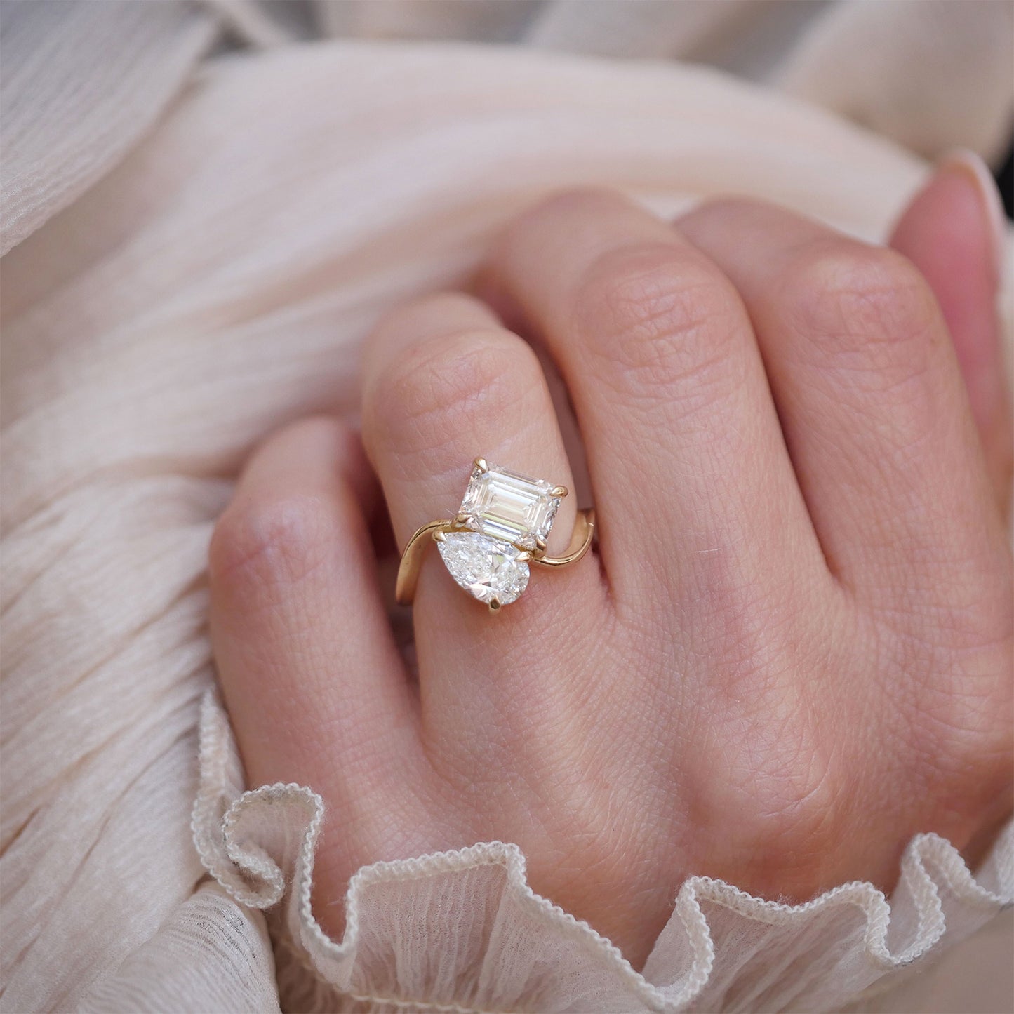 This ring elegantly intertwines the pear and emerald diamonds, creating a dynamic and romantic symbol of love's duality.