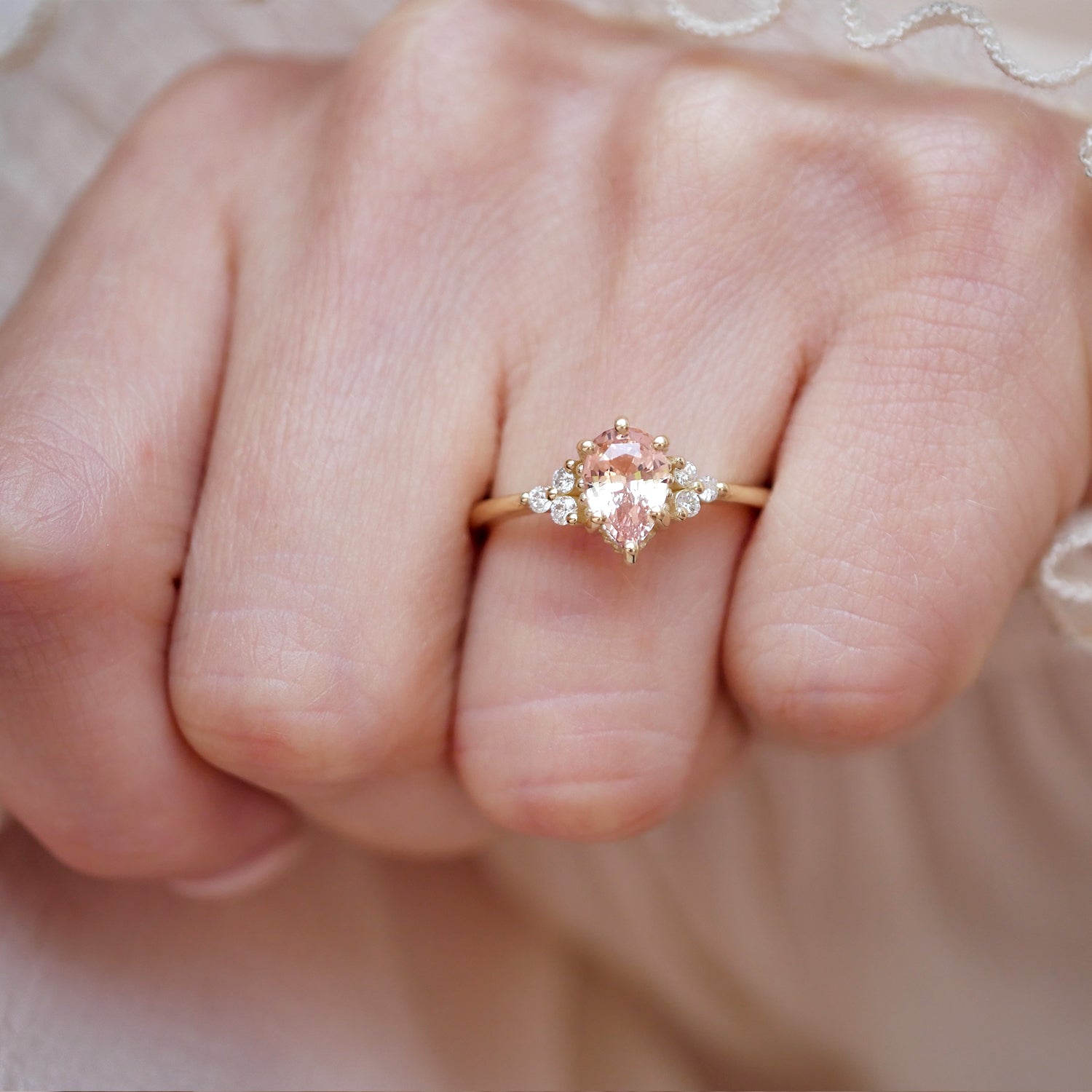 woman wearing 14k yellow gold pear sapphire and round diamond fine jewelry ring