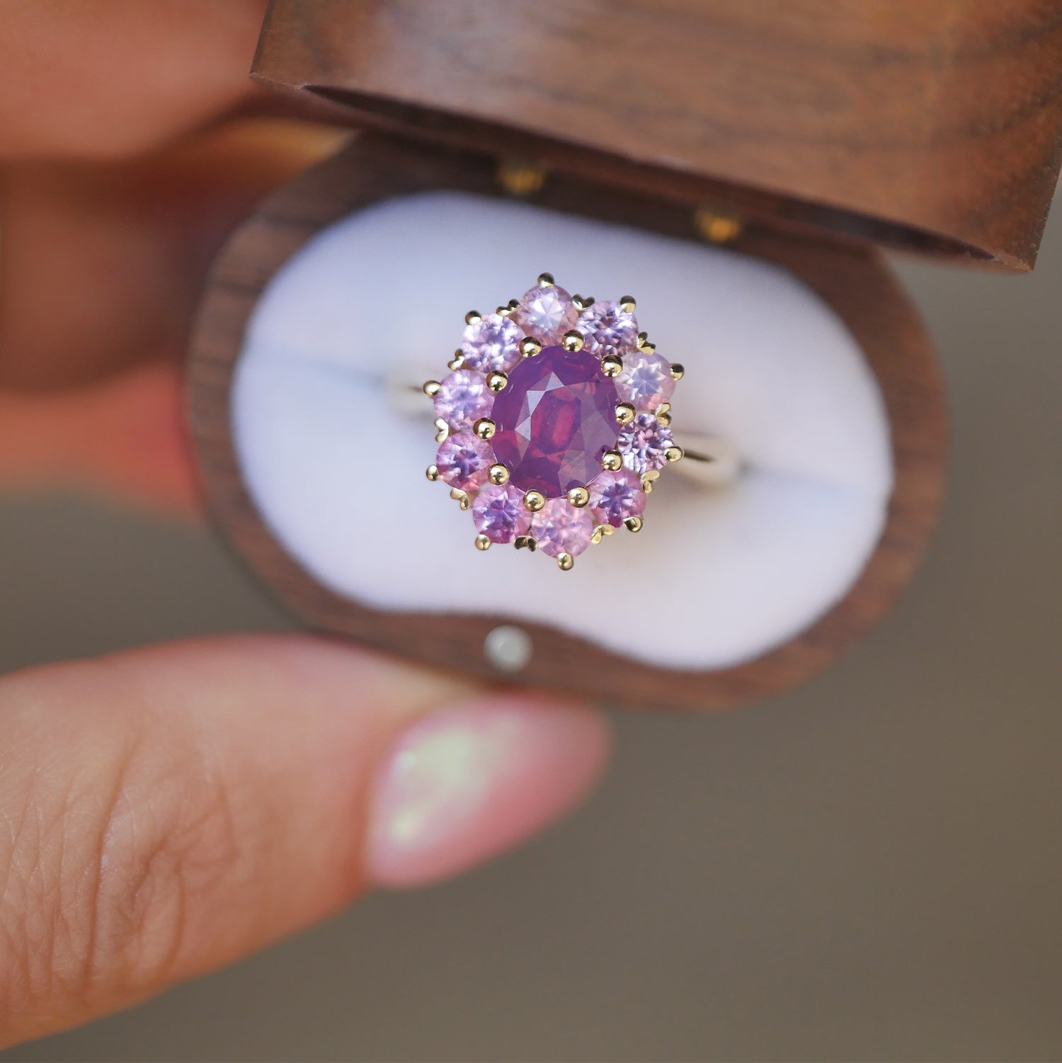 woman holding unique wooden box with a one of a kind vintage inspired cluster ring with purple and pink sapphires