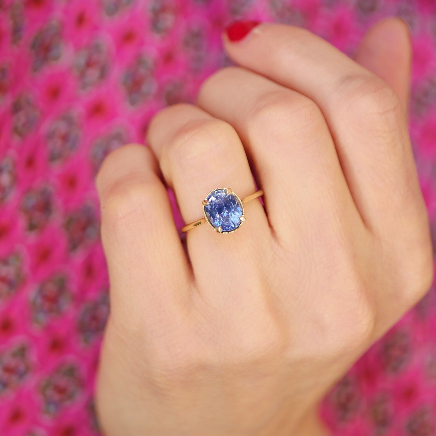 woman wearing oval shaped blue sapphire solitaire