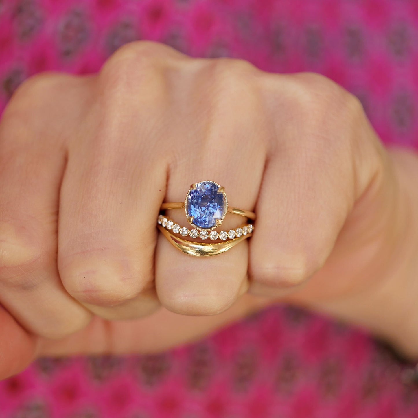 sapphire oval shaped solitaire with a stacked diamond and gold contour band