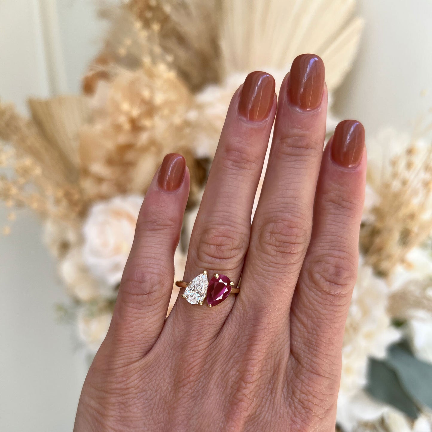 The vivid ruby and the sparkling pear diamond are set side by side in a graceful design, representing the perfect balance between fiery passion and pure brilliance.