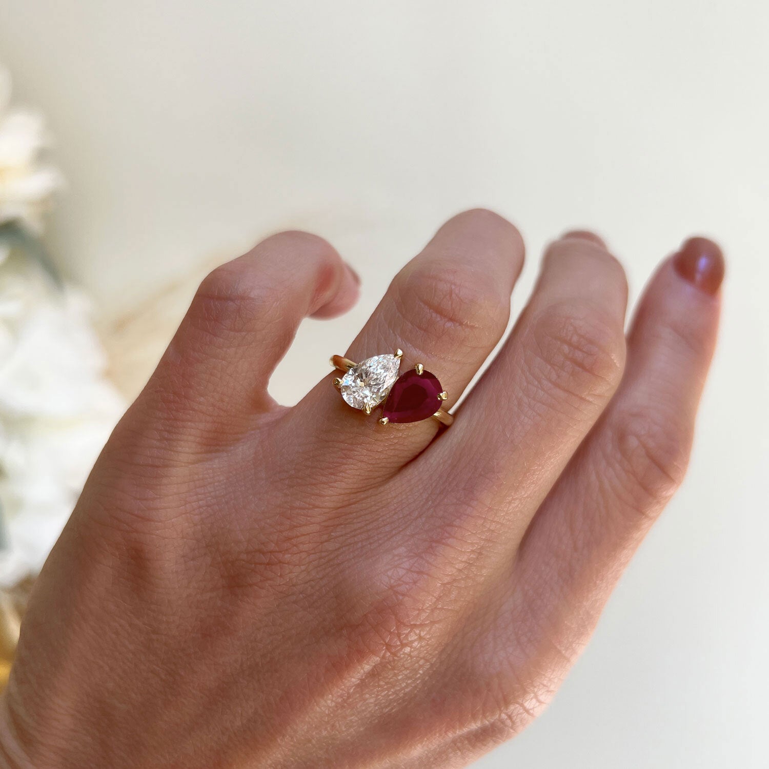 The vivid ruby and the sparkling pear diamond are set side by side in a graceful design, representing the perfect balance between fiery passion and pure brilliance.