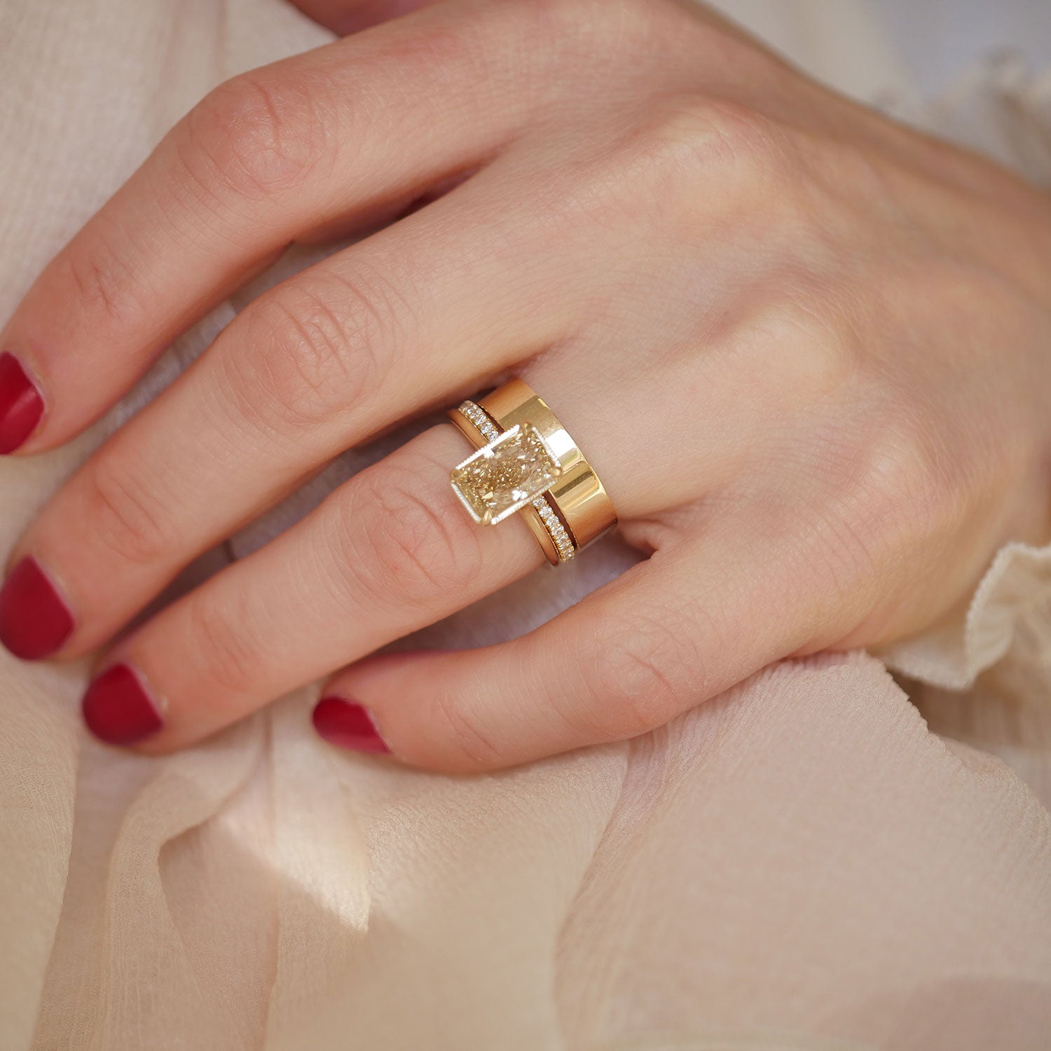 Radiant cut champagne diamond ring with wide cigarette gold band and pave stacked wedding rings