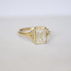 A brilliant lozenge cut diamond at the center of this engagement ring.