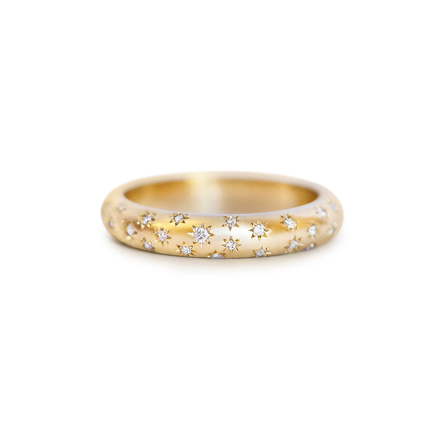 Gold ring with embedded diamonds on engraved stars