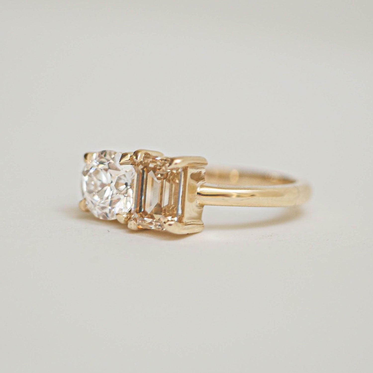 The rich, golden hue of the champagne diamond is perfectly complemented by the brilliance of the round diamond, making this ring an exquisite symbol of love and harmony.