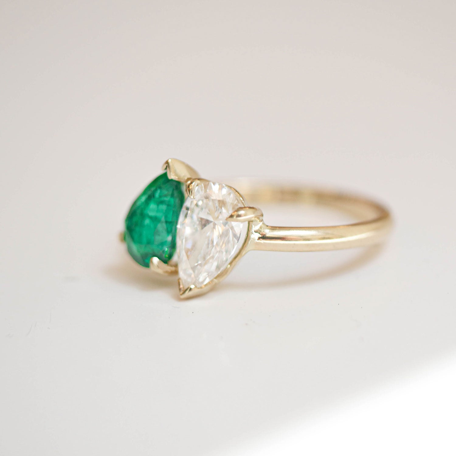 The deep green hue of the pear-shaped emerald and the radiant diamond set side by side symbolize the harmony and balance found in love.