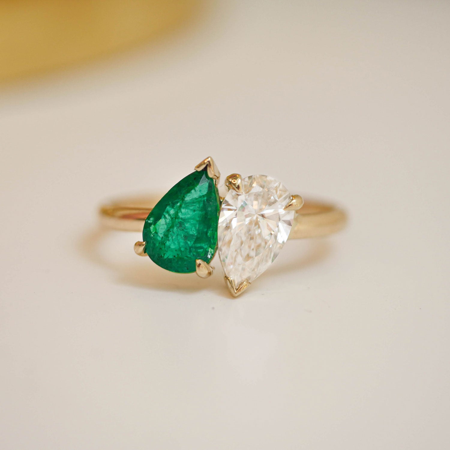The pear-shaped emerald adds a touch of vivid luxury, while the brilliant diamond enhances the ring’s overall sparkle, making it a perfect representation of two souls intertwined.