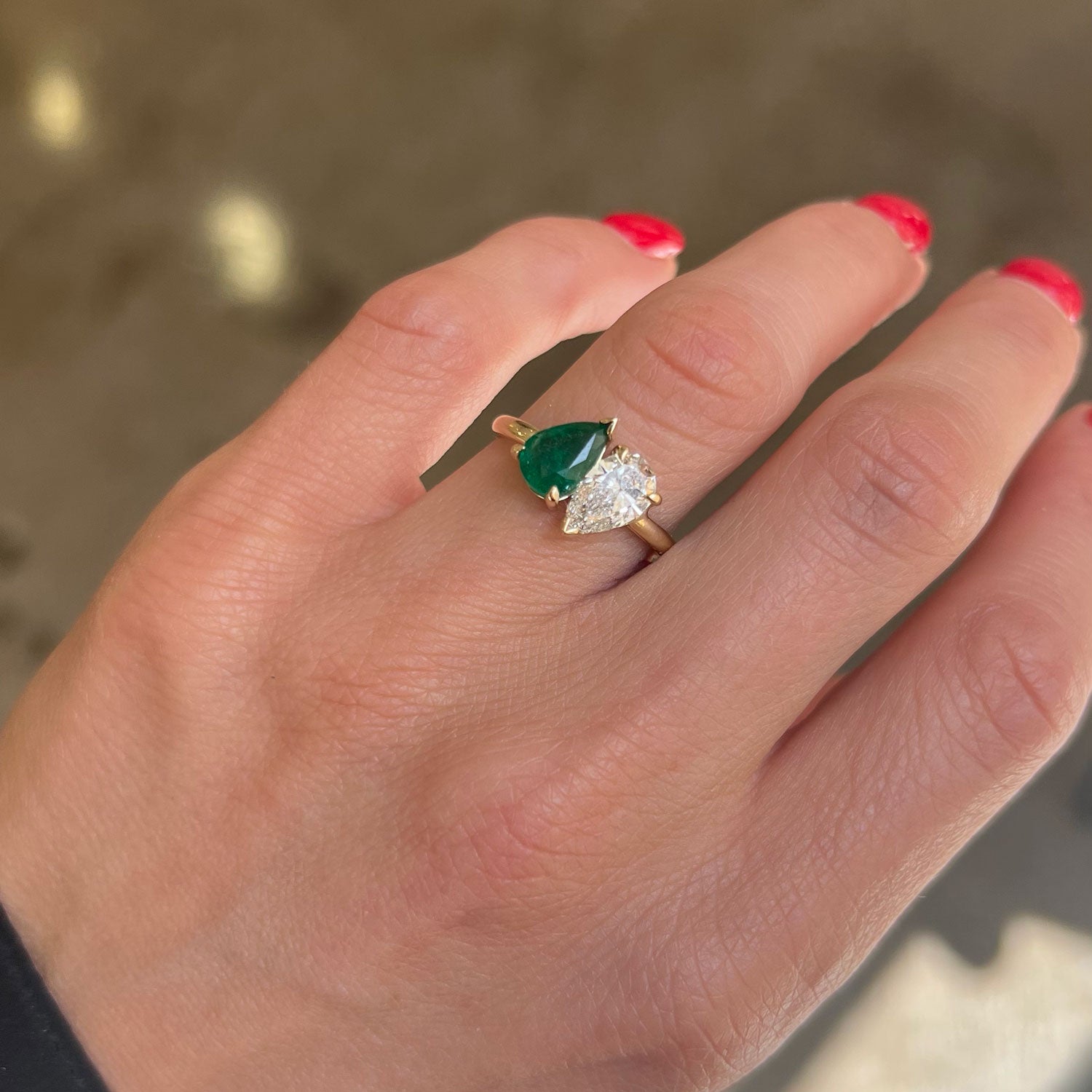 The pear-shaped emerald, symbolizing growth and renewal, beautifully complements the diamond’s brilliance, making this ring a meaningful and stunning expression of love.